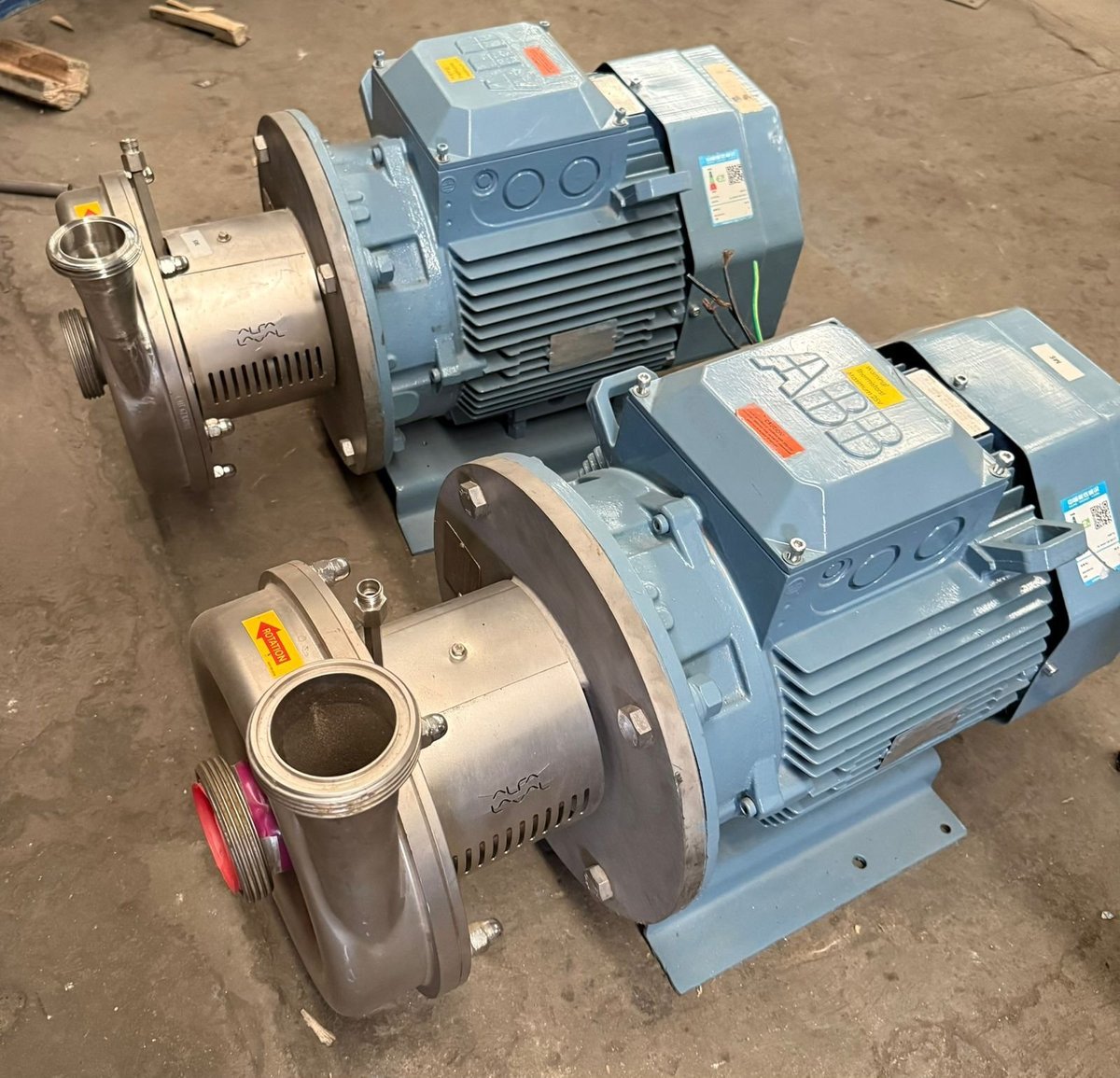 Equipo de bombeo KIN-ROD con dos bombas centrífugas de acero inoxidable y motores eléctricos azules instaladas en piso de taller
