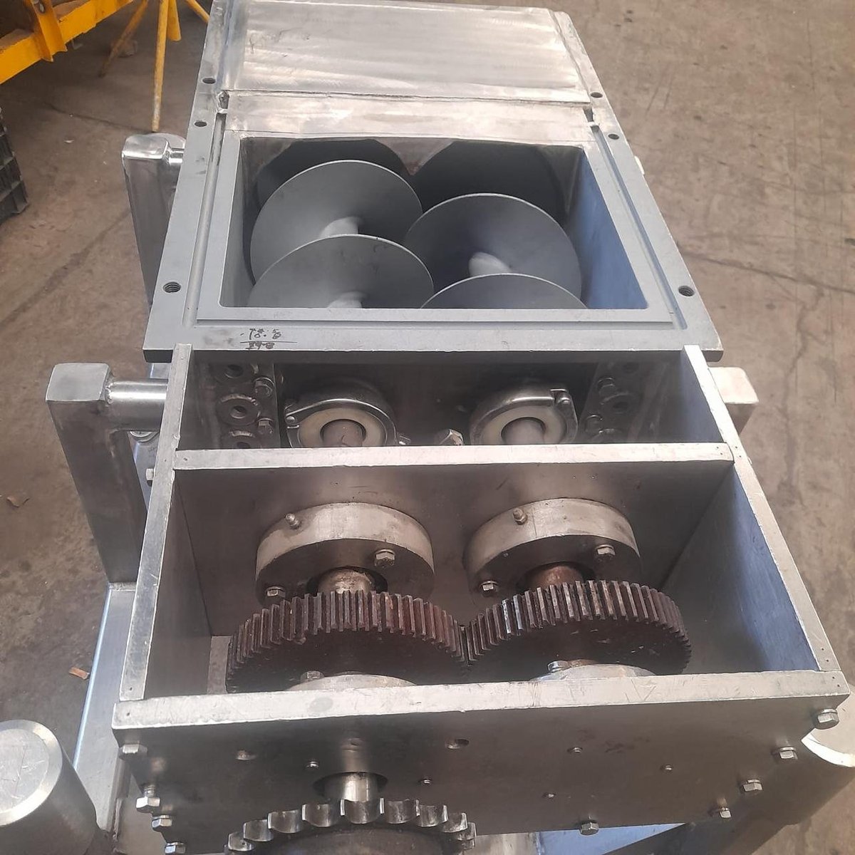 Detalle técnico del extrusor KIN-ROD mostrando el doble gusano de extrusión, transmisión por engranes rectos y motorreductor abierto durante mantenimiento