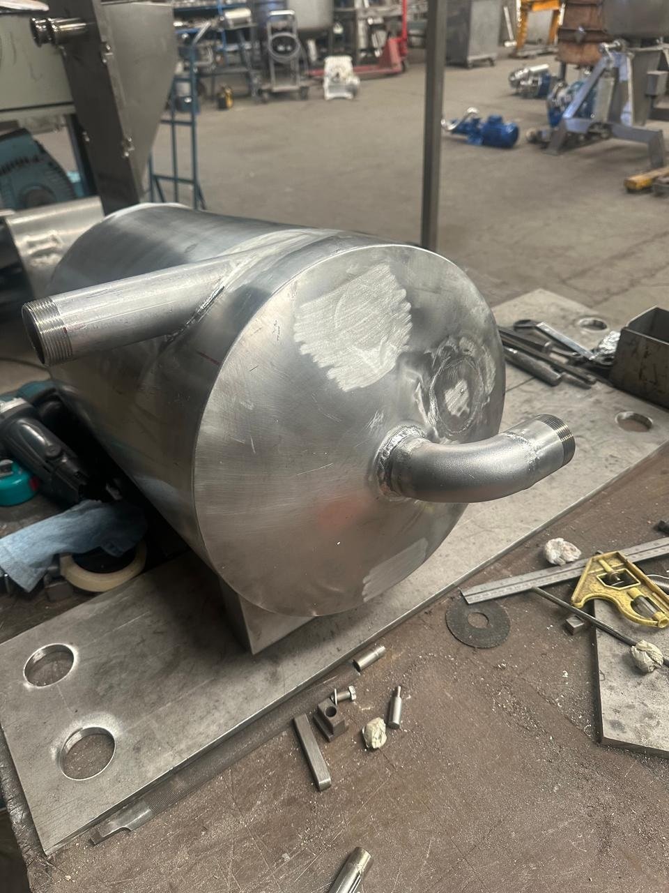 Tanque o recipiente esférico de acero inoxidable soldado en taller KIN-ROD durante su fabricación, con herramientas y conexiones visibles